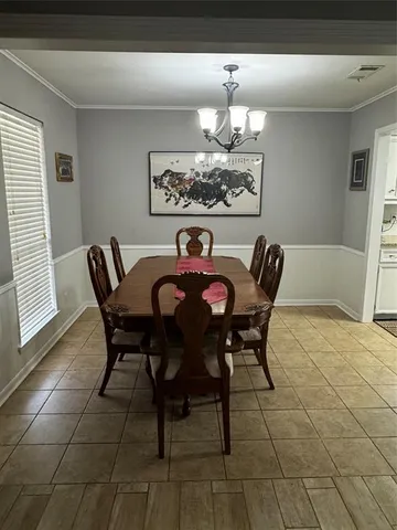 a view of a dining room with furniture and chandelier