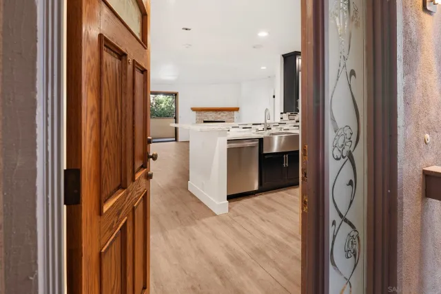 a kitchen with kitchen island wooden floor and refrigerator