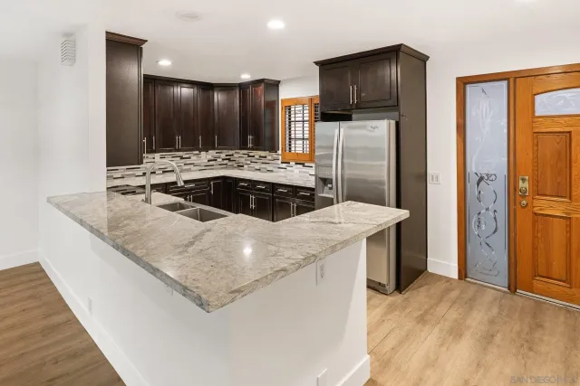 a kitchen with stainless steel appliances granite countertop a sink and a refrigerator