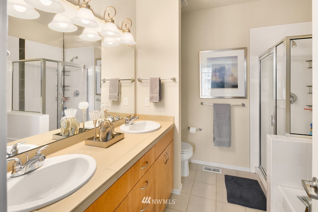 70 Cougar Ridge Road Northwest, Unit 2004 Issaquah, WA 98027 - Photo 16 of 27 a bathroom with a granite countertop sink mirror and a shower