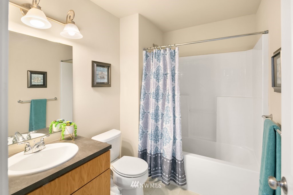 70 Cougar Ridge Road Northwest, Unit 2004 Issaquah, WA 98027 - Photo 18 of 27 a bathroom with a granite countertop sink toilet and shower