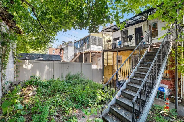 a view of a house with a small yard and large trees