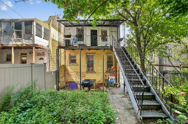 a stone house with large trees in front of it