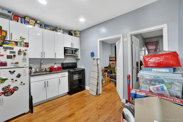 a kitchen with stainless steel appliances granite countertop a sink dishwasher and a refrigerator with wooden floor