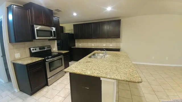 a kitchen with stainless steel appliances granite countertop a sink and a stove