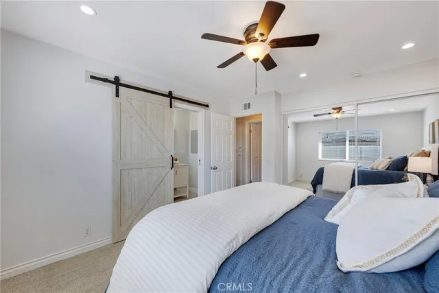 a bedroom with a large bed and a ceiling fan