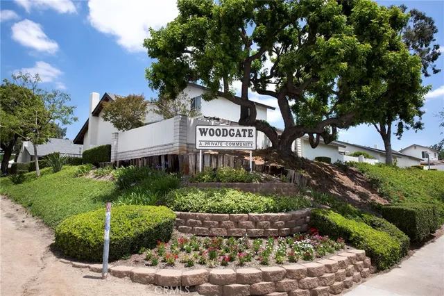 a sign that is sitting in front of a tree