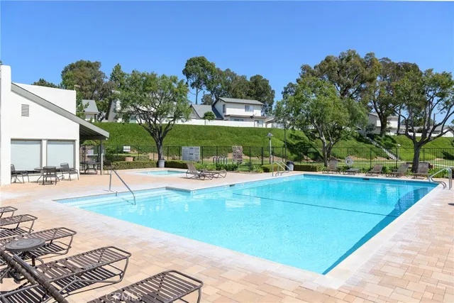 a view of a swimming pool with a patio and a yard