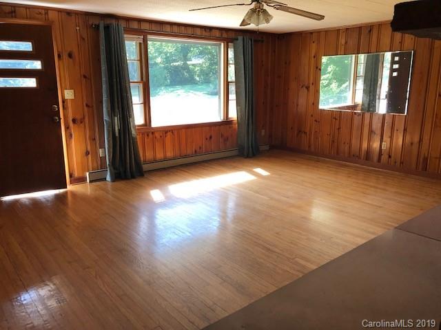 849 Fairview Road Marion, NC 28752 - Photo 3 of 15 an empty room with wooden floor and windows