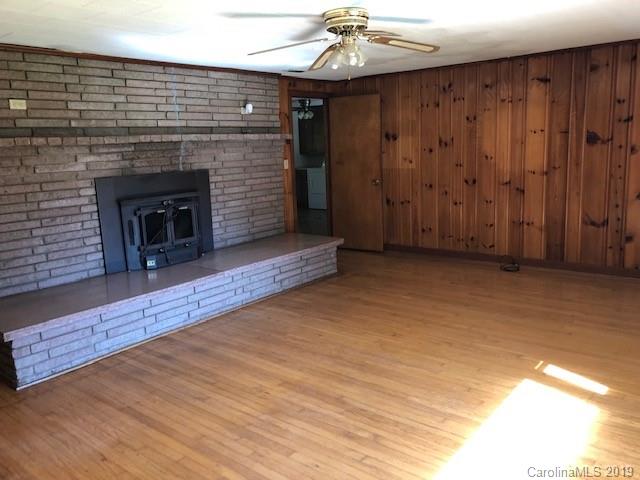 849 Fairview Road Marion, NC 28752 - Photo 4 of 15 a view of an empty room with wooden floor fireplace and a window
