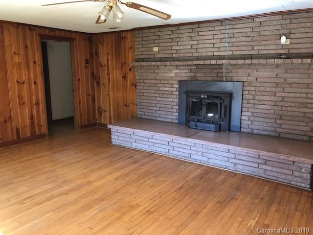 849 Fairview Road Marion, NC 28752 - Photo 5 of 15 a view of an empty room with wooden floor fireplace and a window