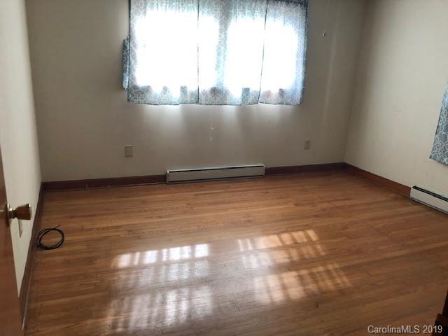 849 Fairview Road Marion, NC 28752 - Photo 6 of 15 an empty room with wooden floor and windows