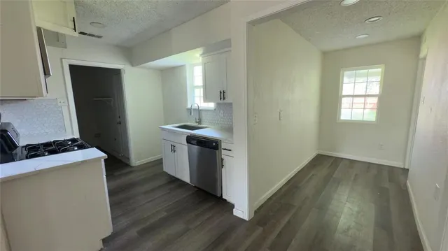 a kitchen with a sink and wooden floor