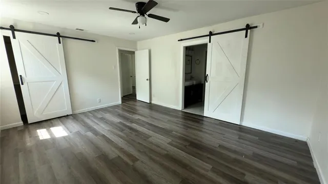 a view of empty room with wooden floor and window