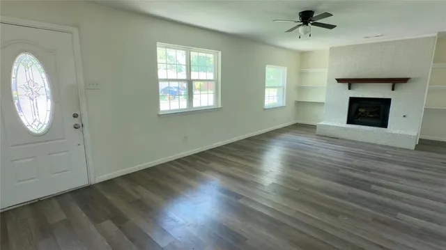 an empty room with windows fireplace and a sink