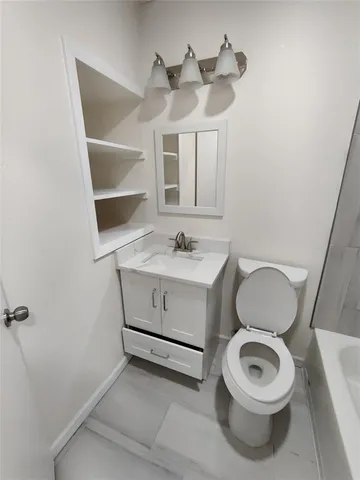 a bathroom with a toilet a sink and a mirror