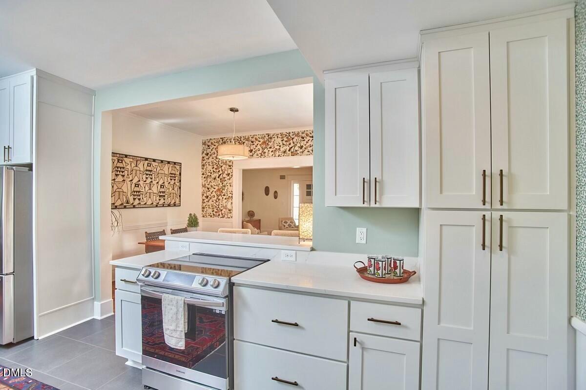 1313 Watts Street Durham, NC 27701 - Photo 21 of 44 a kitchen with stainless steel appliances granite countertop a stove a sink and a refrigerator