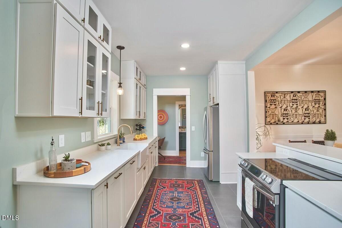 1313 Watts Street Durham, NC 27701 - Photo 22 of 44 a kitchen with a sink stove and cabinets