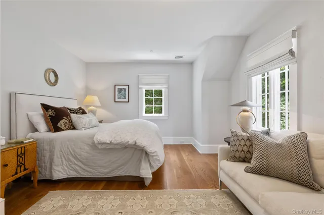 a bathroom with a granite countertop toilet a sink a mirror and a window