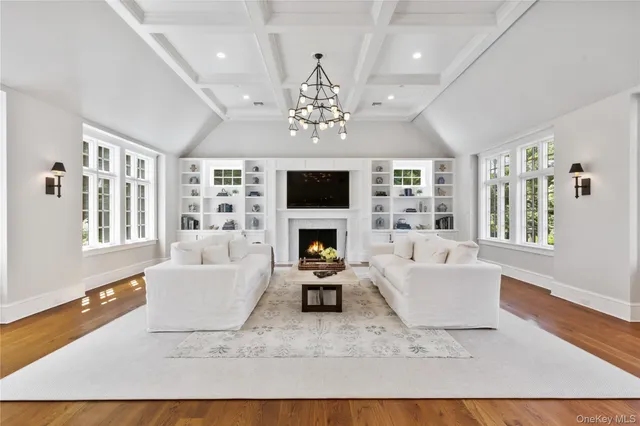 a living room with furniture a fireplace and a large window