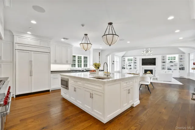 a kitchen with stainless steel appliances granite countertop a stove oven and a view of living room