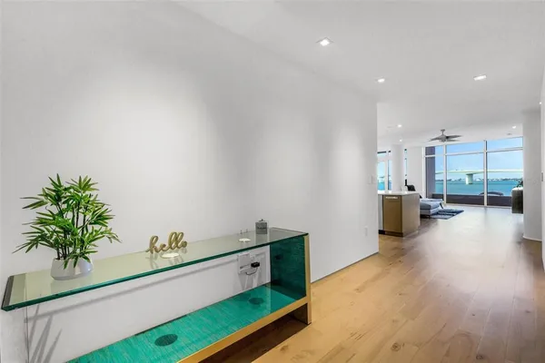 a kitchen with stainless steel appliances kitchen island a white stove top oven and a sink with wooden floor