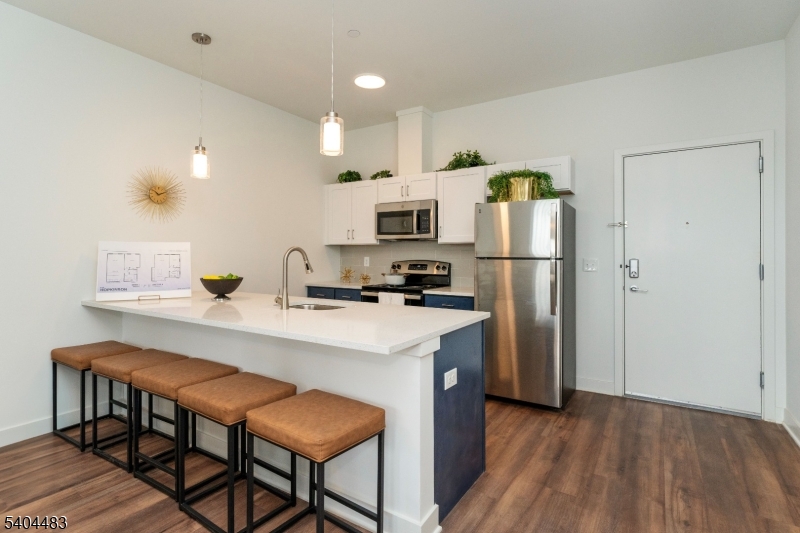 18 West Main Street, Unit 412 Bound Brook, NJ 08805 - Photo 3 of 27 a kitchen with kitchen island a refrigerator stove and microwave