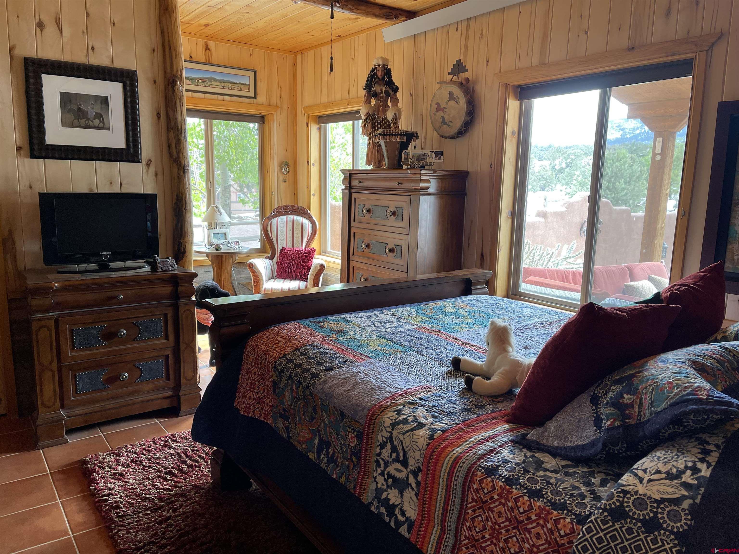 521 Dilley Ranch Road Canon City, CO 81212 - Photo 9 of 20 a bedroom with a bed and dresser with mirror