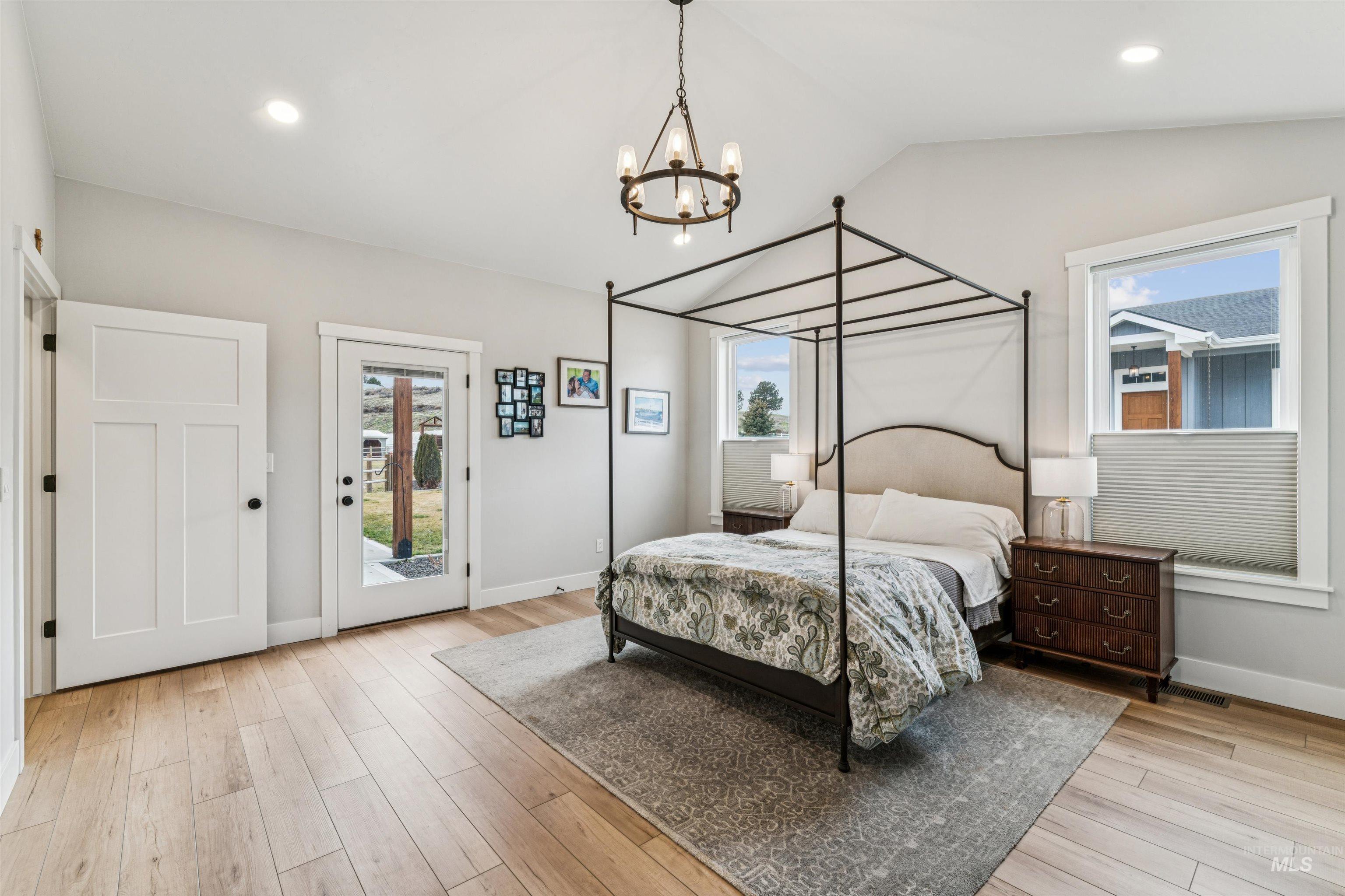 547 Bass Run Lane Marsing, ID 83639 - Photo 20 of 49 Bedroom with vaulted ceiling, multiple windows, access to exterior, light wood finished floors, and suspended lighting