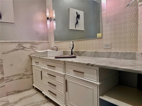 a bathroom with a granite countertop sink a mirror and vanity