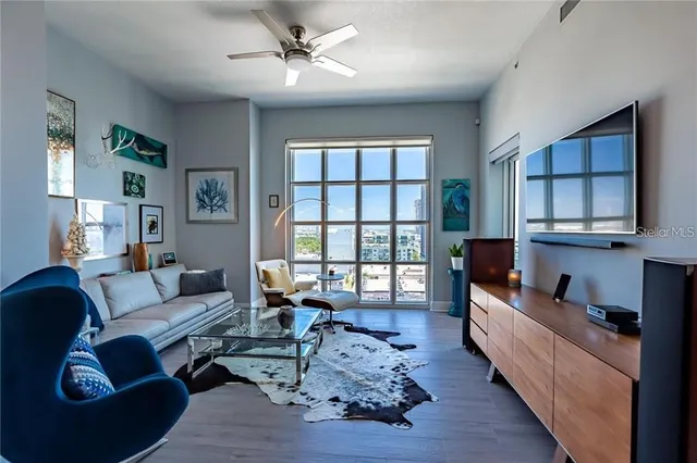 a living room with furniture wooden floor and a large window