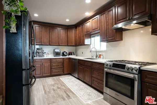 a kitchen with stainless steel appliances granite countertop a stove a sink dishwasher and a refrigerator