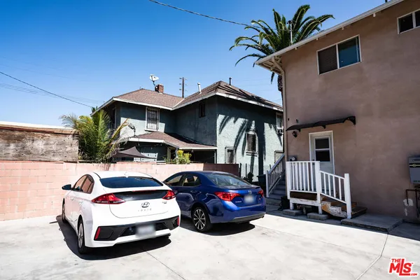 a car parked in front of a house with wooden fence