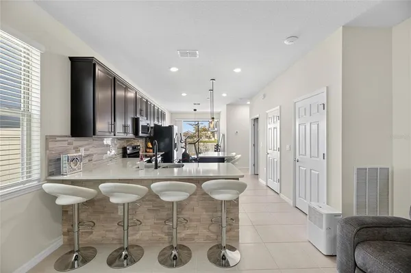 a kitchen with stainless steel appliances kitchen island granite countertop a table and chairs