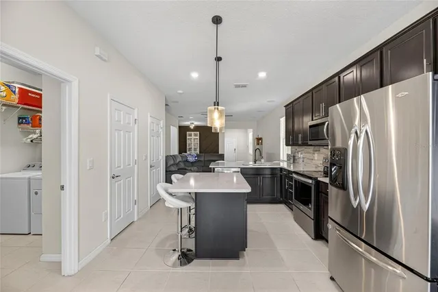 a kitchen with stainless steel appliances a refrigerator sink and microwave