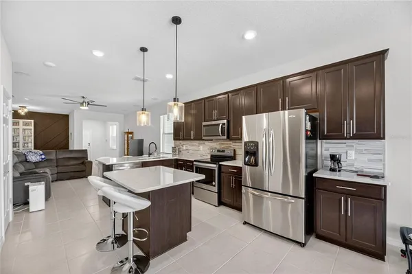 a kitchen with stainless steel appliances granite countertop a sink refrigerator and cabinets