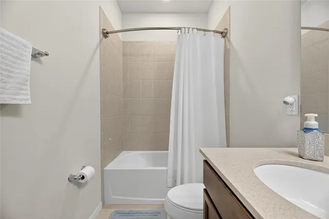 a bathroom with a sink a toilet a mirror and shower