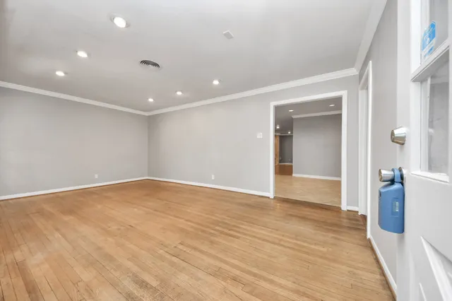 a view of an empty room with wooden floor