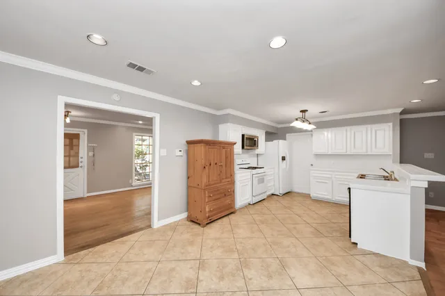 a view of a kitchen with refrigerator and a sink