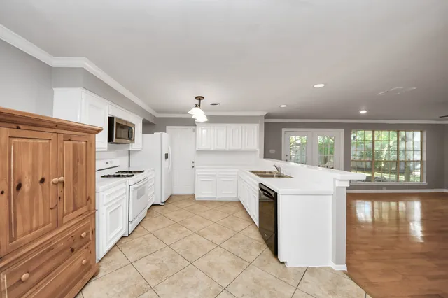 a kitchen with granite countertop a sink stove and cabinets