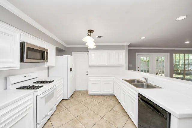 a kitchen with a refrigerator sink and cabinets