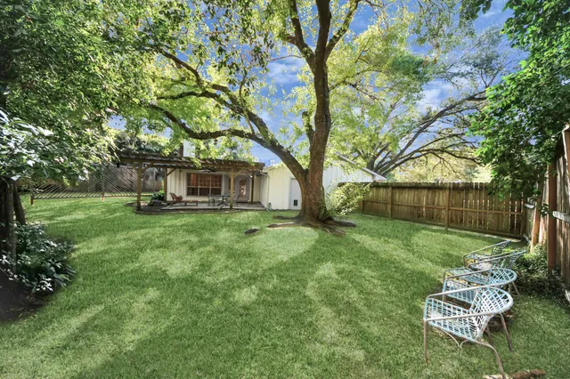 a view of a chair and table in backyard of the house