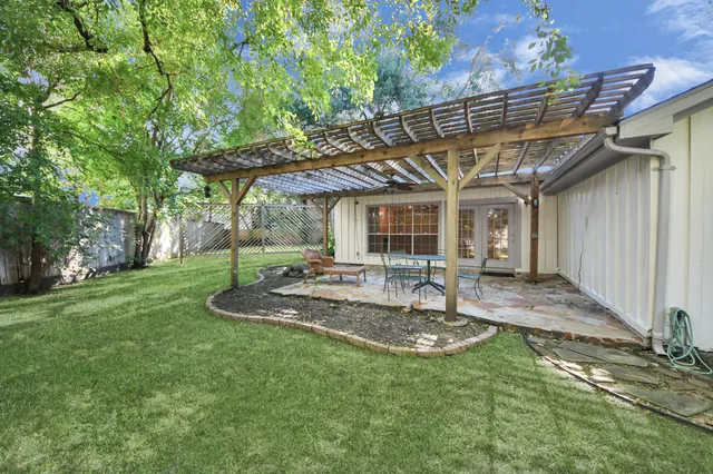 a view of a chair and table in backyard of the house