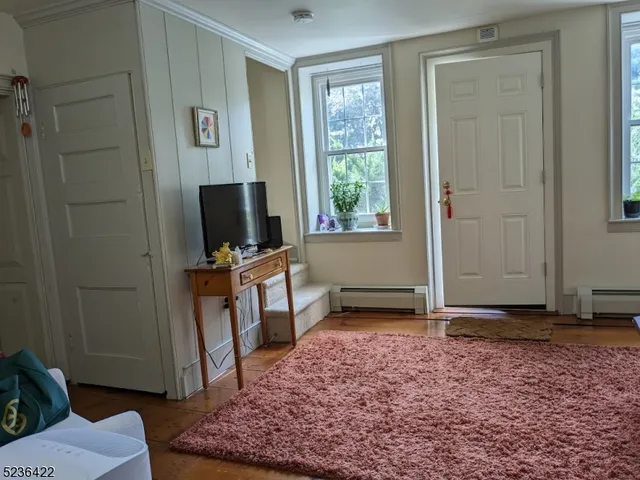 a view of a livingroom with wooden floor and a flat screen tv