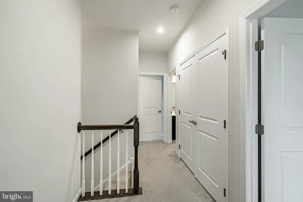 a view of a hallway with white walls and white doors