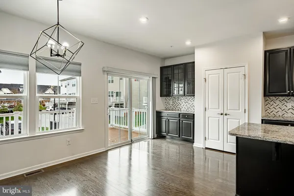 a view of a kitchen with stainless steel appliances granite countertop a stove and wooden floors