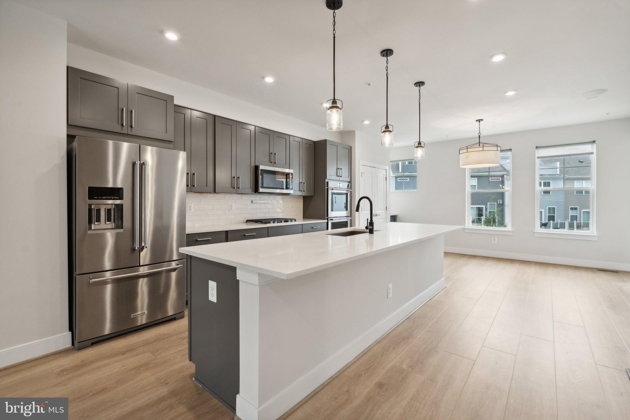 3034 Declan Way Falls Church, VA 22044 - Photo 6 of 41 a kitchen with kitchen island a sink stainless steel appliances and wooden floor