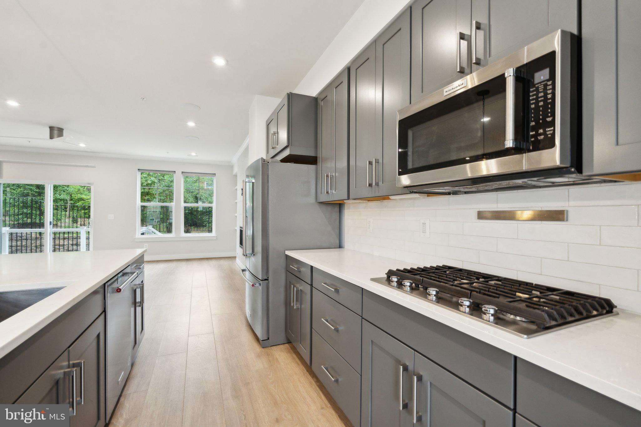 3034 Declan Way Falls Church, VA 22044 - Photo 7 of 41 a kitchen with stainless steel appliances a sink a stove a microwave cabinets and wooden floor