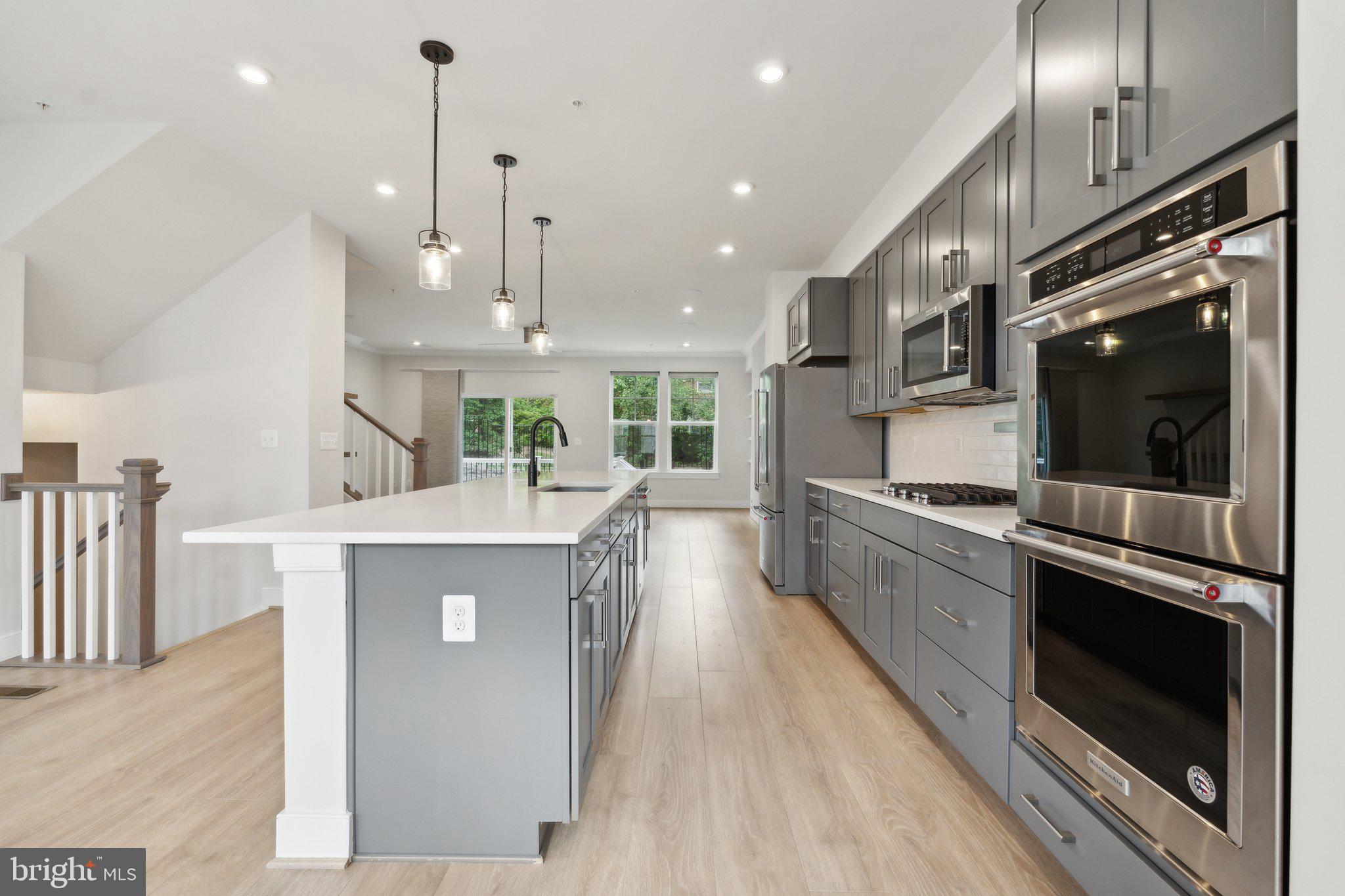 3034 Declan Way Falls Church, VA 22044 - Photo 9 of 41 a kitchen with kitchen island a counter top space a sink stainless steel appliances and cabinets