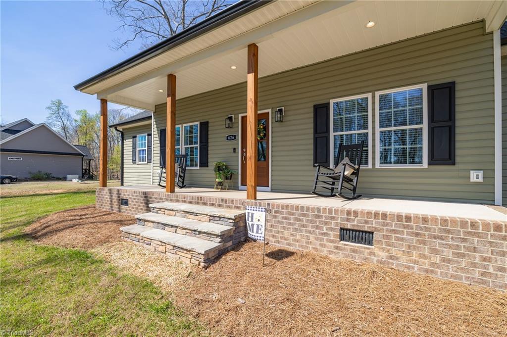 626 Bethany Road Reidsville, NC 27320 - Photo 6 of 42 Covered front porch at 626 Bethany Road, Reidsville, NC 27320, Rockingham County. Stained cedar posts, stacked stone entry steps, brick foundation, recessed porch lighting, and wood front door. Bethany Community.